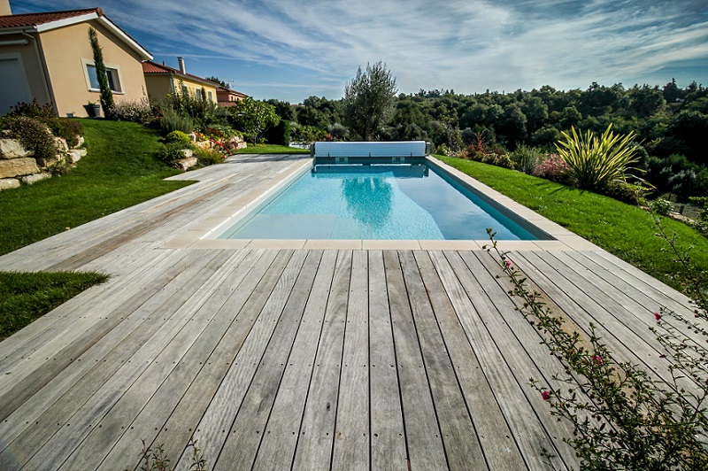Terrasse en bois autour d'une piscine avec volet hors sol