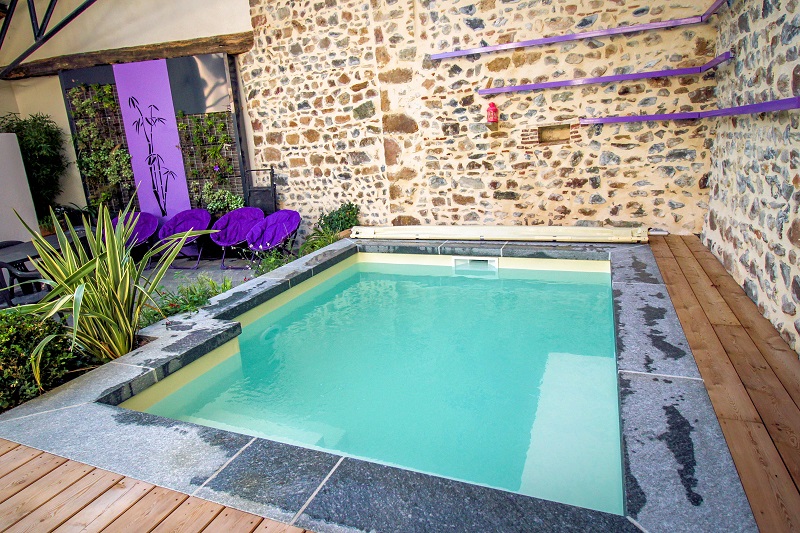 Petite piscine créee dans une cour intérieure, pvc alkorplan beige, banquette bois